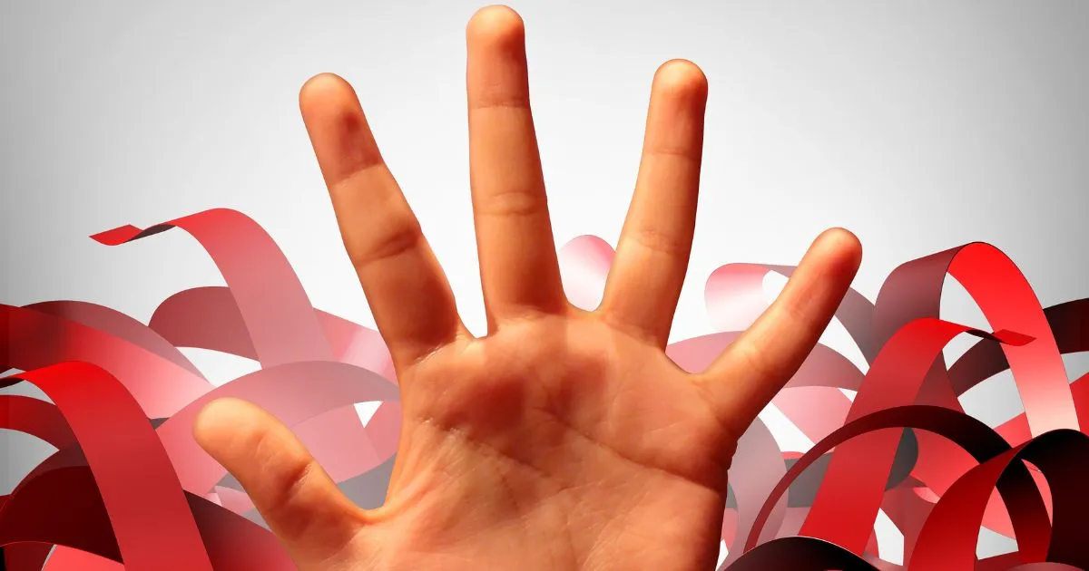 Hand with fingers outstretched emerges from a pile of red ribbons.