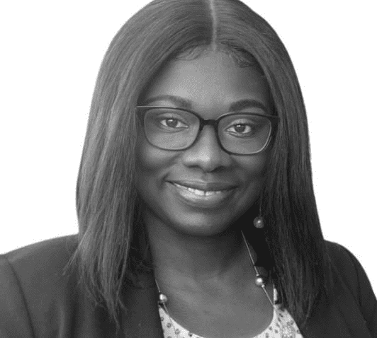 Black woman with straight shoulder-length hair. She is smiling and wearing glasses.